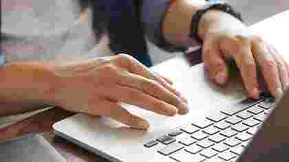 OCU Online Management Degree student with laptop