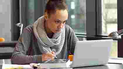 Online student at library listening to human resources lecture