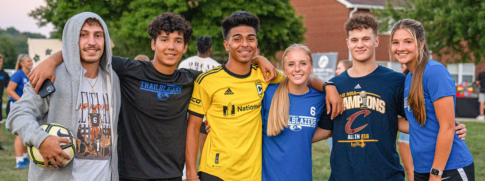 Students on campus together arm in arm